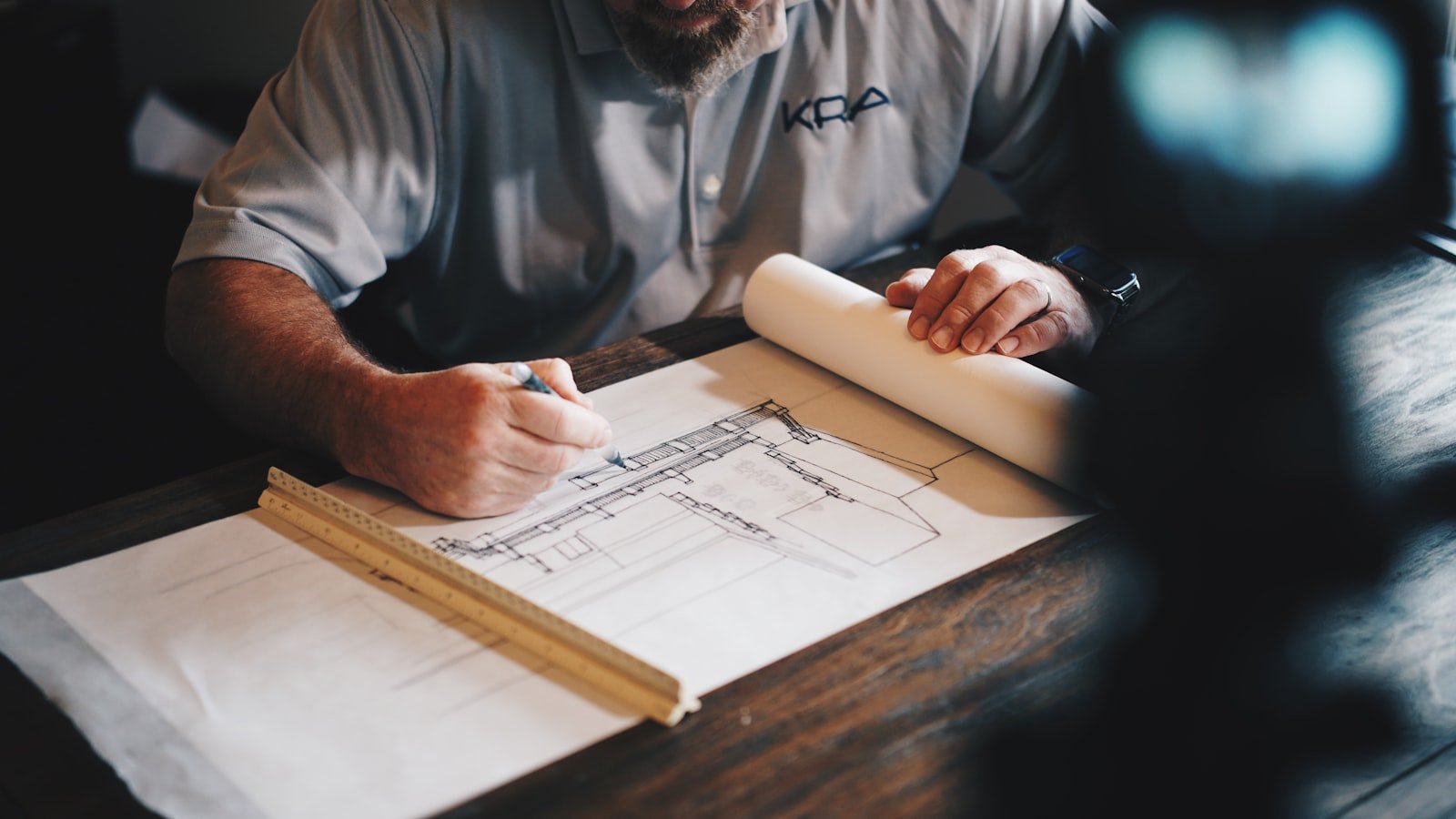 “We Don’t Even Know What He Knows”: The Bus Factor in Mid-Sized Companies 2 Engineer drawing a technical blueprint with pencil and ruler